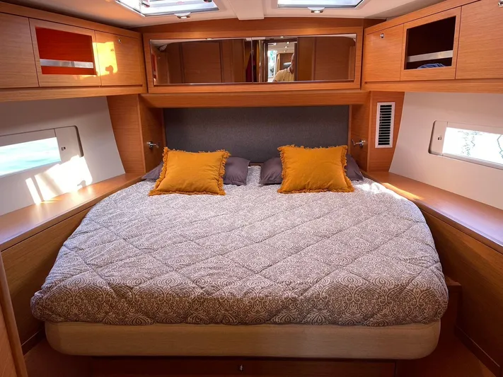  Yacht Photos Pics Luxurious cabin interior of 2022 Dufour 470 yacht with cozy bedding and wooden accents.
