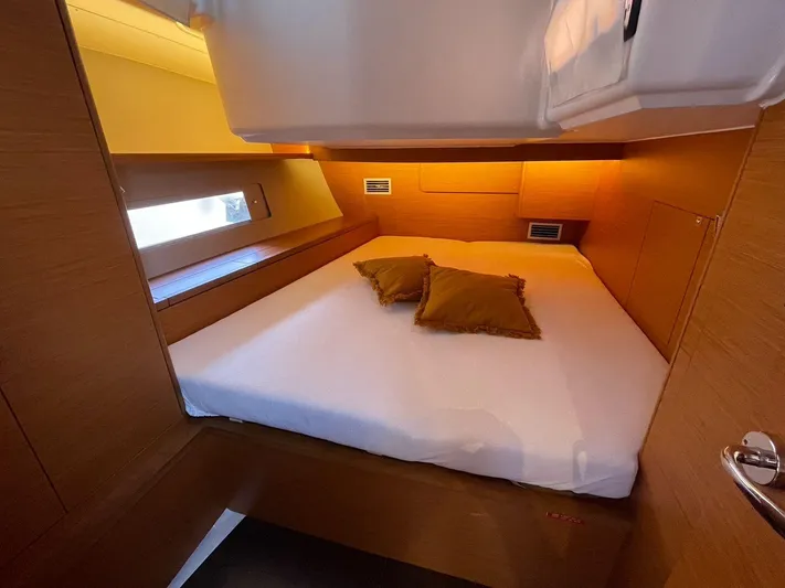 Yacht Photos Pics Luxurious cabin interior of 2022 Dufour 470 yacht with cozy bed and warm lighting.