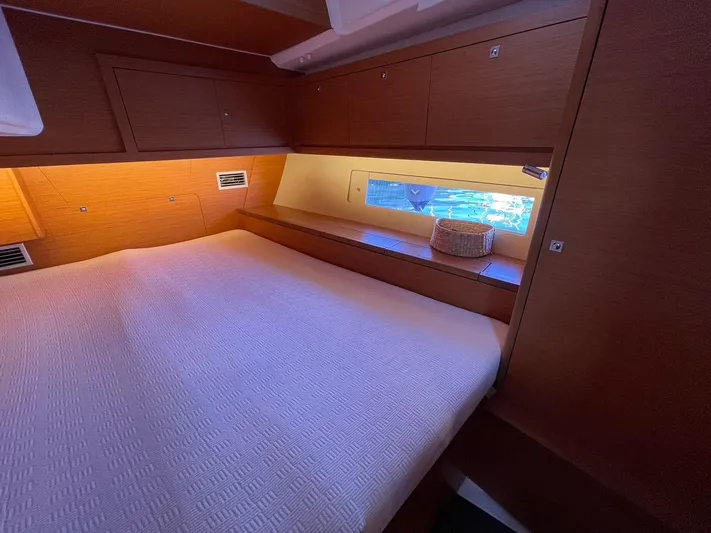  Yacht Photos Pics Cozy cabin interior of 2022 Dufour 470 yacht with wooden finish and window view.