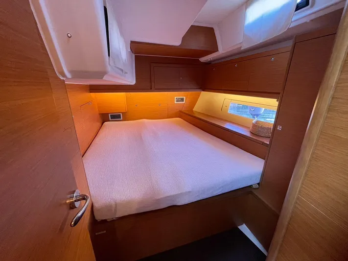  Yacht Photos Pics Cozy cabin interior of 2022 Dufour 470 yacht with wooden finish and comfortable bedding.