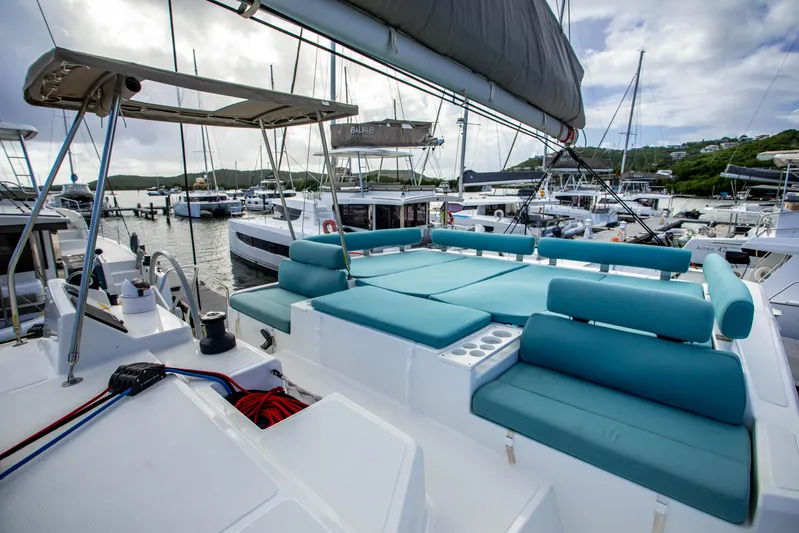 Lucky Fin Yacht Photos Pics 2024 Bali CATSPACE catamaran with turquoise seating, docked at a marina under a cloudy sky.