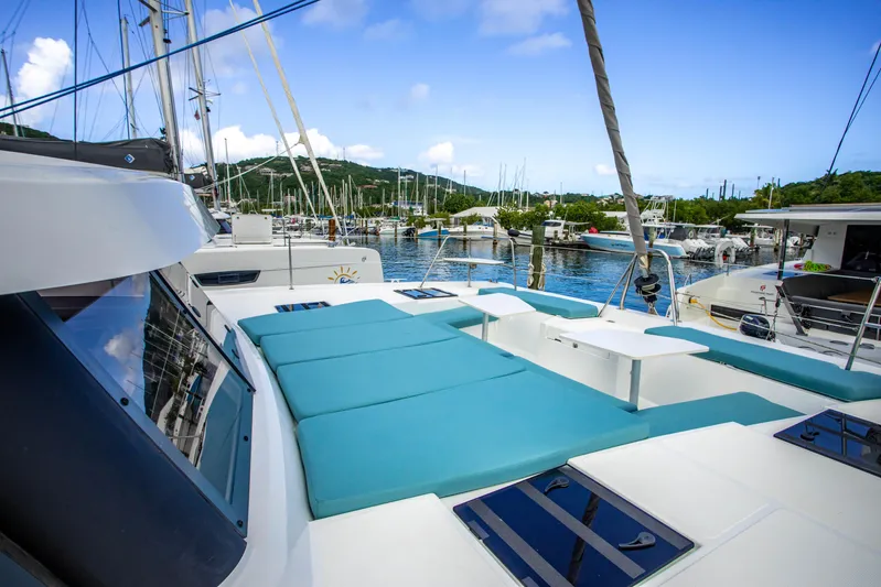 Lucky Fin Yacht Photos Pics 2024 Bali CATSPACE catamaran with spacious deck, docked in a scenic marina.