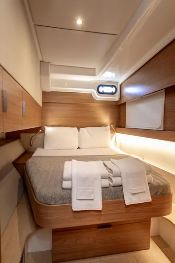 Lucky Fin Yacht Photos Pics Luxurious 2024 Bali CATSPACE yacht cabin with cozy bed and modern wooden interior design.
