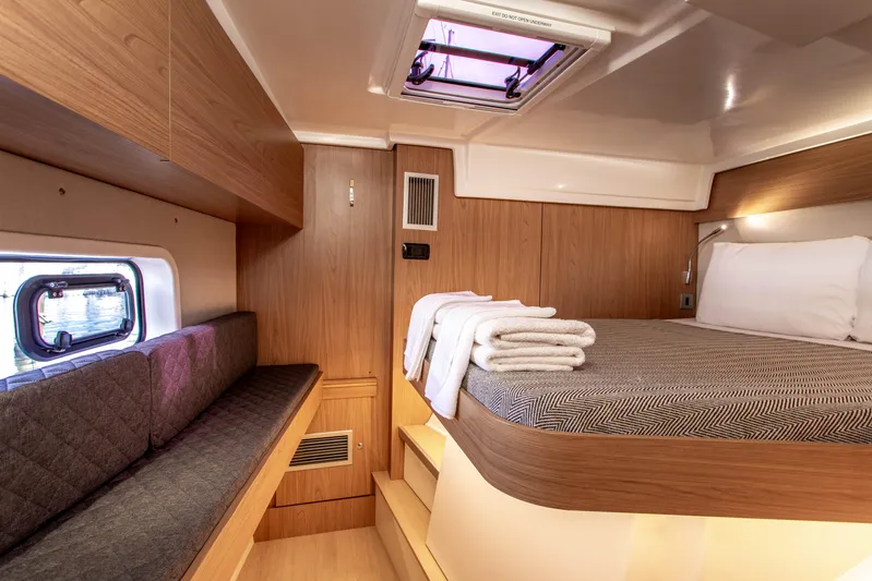 Lucky Fin Yacht Photos Pics 2024 Bali CATSPACE cabin interior with bed, seating, and window.