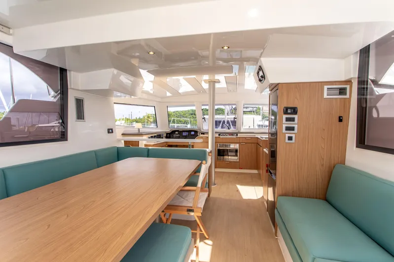 Lucky Fin Yacht Photos Pics Spacious interior of 2024 Bali CATSPACE catamaran with modern kitchen and seating area.