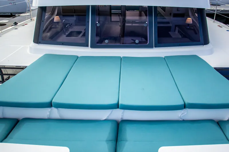 Lucky Fin Yacht Photos Pics 2024 Bali CATSPACE catamaran with turquoise deck cushions and large windows.