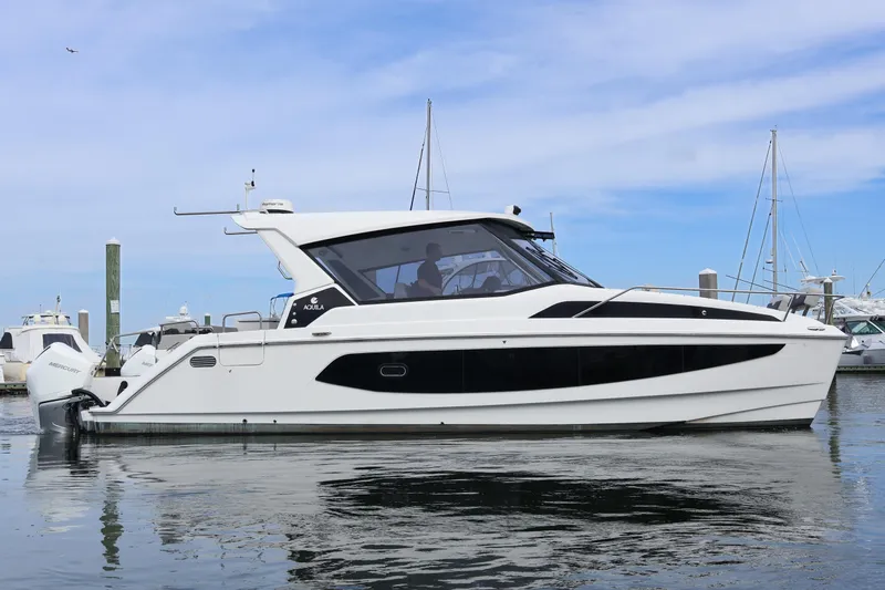  Yacht Photos Pics 2023 Aquila 36 Sport yacht docked in marina, sleek design, calm waters, clear sky.