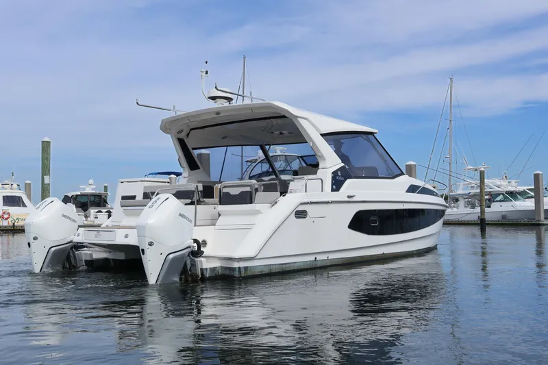  Yacht Photos Pics 2023 Aquila 36 Sport boat docked in marina, featuring sleek design and twin outboard engines.
