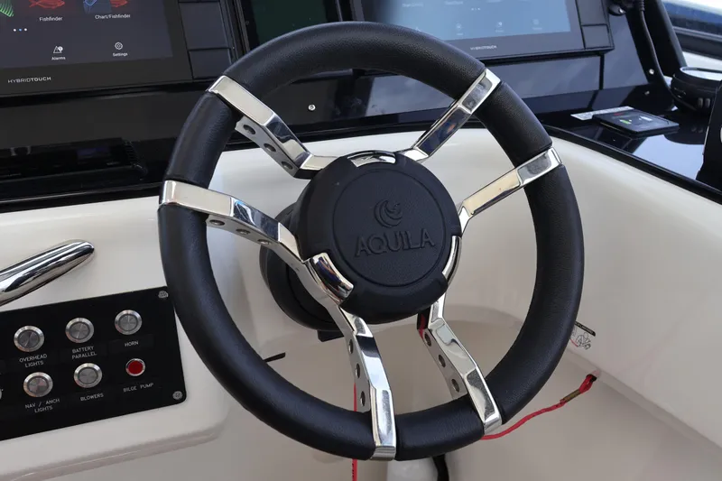  Yacht Photos Pics Steering wheel of 2023 Aquila 36 Sport boat with control panel and touchscreen display.