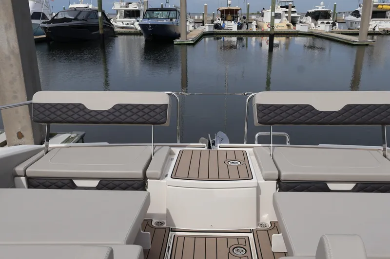  Yacht Photos Pics 2023 Aquila 36 Sport boat interior with cushioned seating at marina.