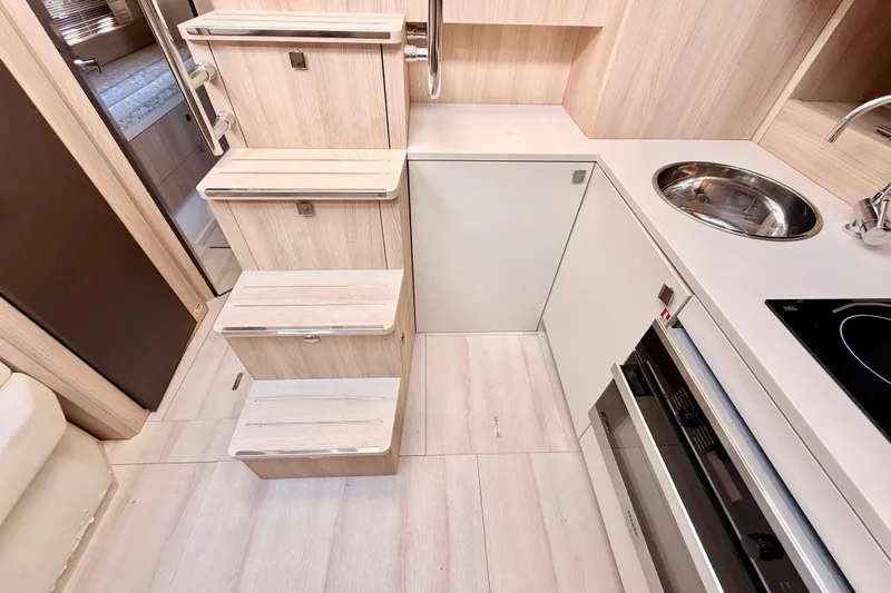  Yacht Photos Pics Interior of 2016 Cranchi M44 HT yacht featuring compact kitchen and wooden stairs.