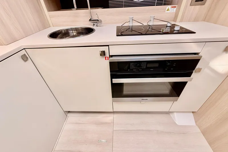  Yacht Photos Pics Modern kitchen in 2016 Cranchi M44 HT yacht with stove, sink, and Miele oven.