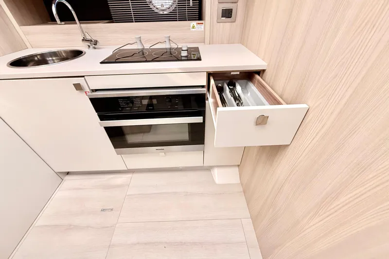  Yacht Photos Pics Modern kitchen in 2016 Cranchi M44 HT yacht with stove, sink, and open drawer.
