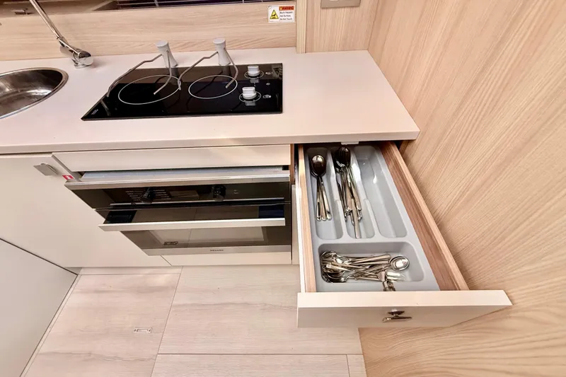  Yacht Photos Pics Modern kitchen in 2016 Cranchi M44 HT yacht with stove, oven, and open cutlery drawer.