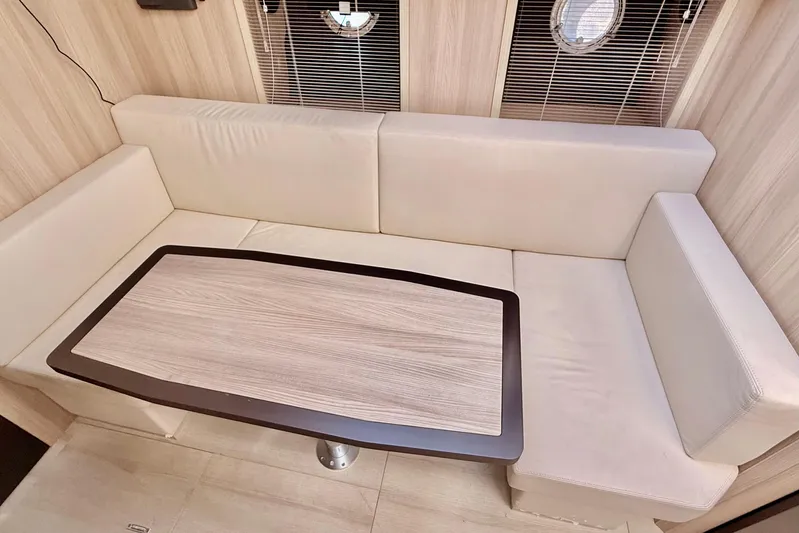  Yacht Photos Pics Luxurious interior of 2016 Cranchi M44 HT yacht with beige seating and wooden table.