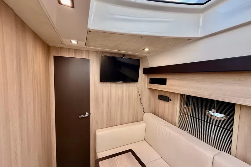  Yacht Photos Pics Interior of 2016 Cranchi M44 HT yacht with modern wood paneling and a mounted TV.