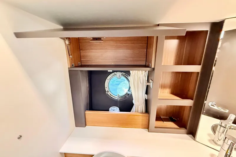  Yacht Photos Pics Interior of 2016 Cranchi M44 HT yacht with wooden cabinets and porthole window.