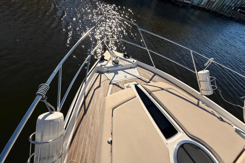 Yacht Photos Pics Bow view of 2016 Cranchi M44 HT yacht with sunlit water reflections.