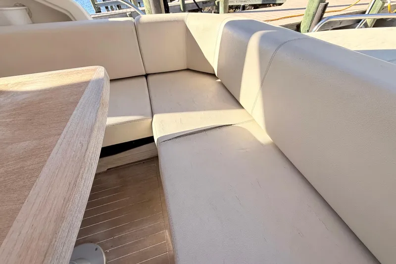  Yacht Photos Pics Beige seating area on 2016 Cranchi M44 HT yacht with wooden table.
