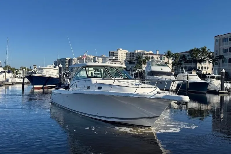  Yacht Photos Pics 2021 Pursuit OS 385 Offshore boat docked in a marina under clear blue skies.