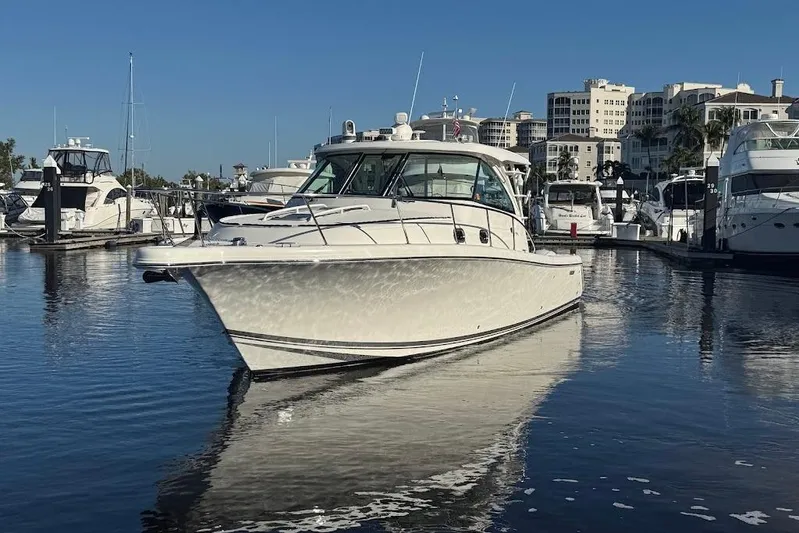  Yacht Photos Pics 2021 Pursuit OS 385 Offshore boat docked in a marina with clear blue skies.