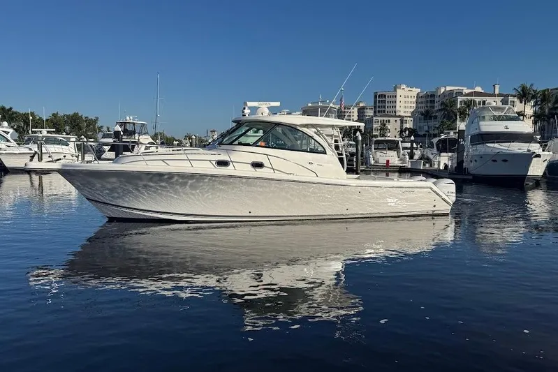  Yacht Photos Pics 2021 Pursuit OS 385 Offshore boat docked in a marina, reflecting on calm water.