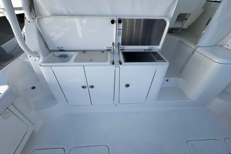  Yacht Photos Pics 2021 Pursuit OS 385 Offshore boat interior with storage compartments and sink.