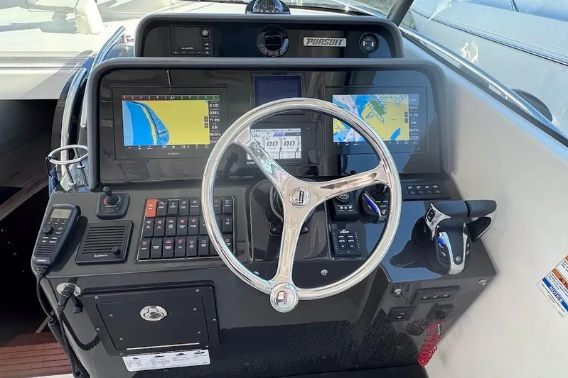  Yacht Photos Pics Control panel of 2021 Pursuit OS 385 Offshore boat with navigation screens and steering wheel.