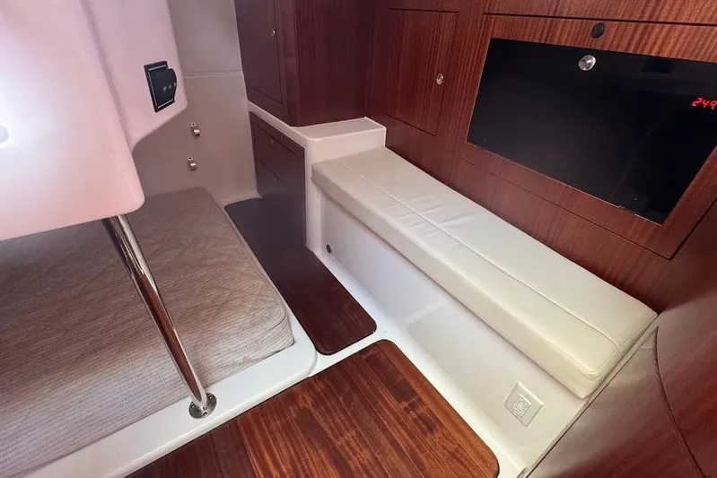  Yacht Photos Pics 2021 Pursuit OS 385 Offshore cabin interior with wood finish and seating area.