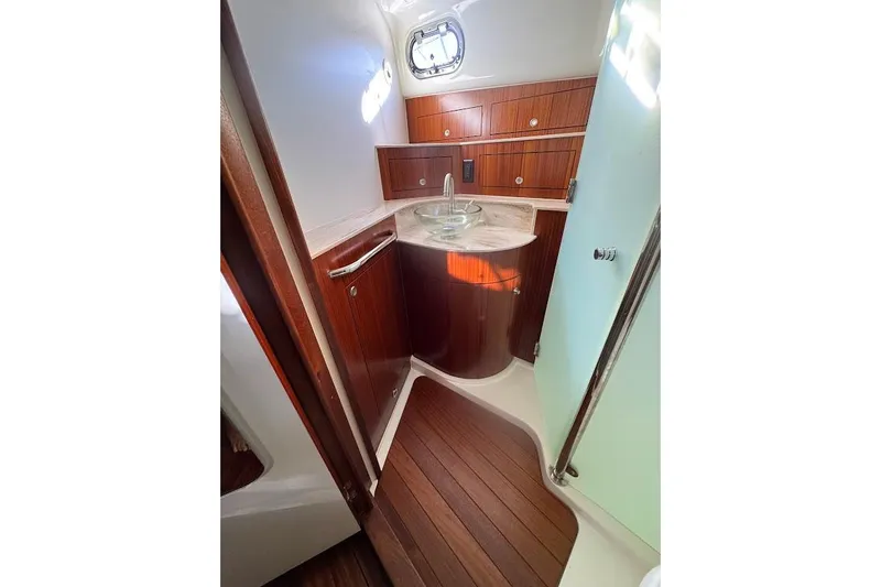  Yacht Photos Pics 2021 Pursuit OS 385 Offshore yacht bathroom with wood cabinetry and modern sink.