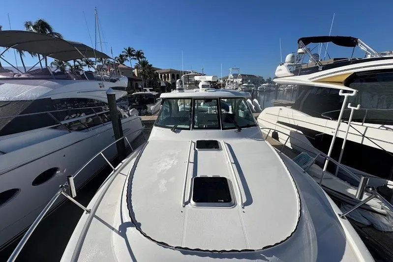  Yacht Photos Pics 2021 Pursuit OS 385 Offshore boat docked among other yachts in a marina.