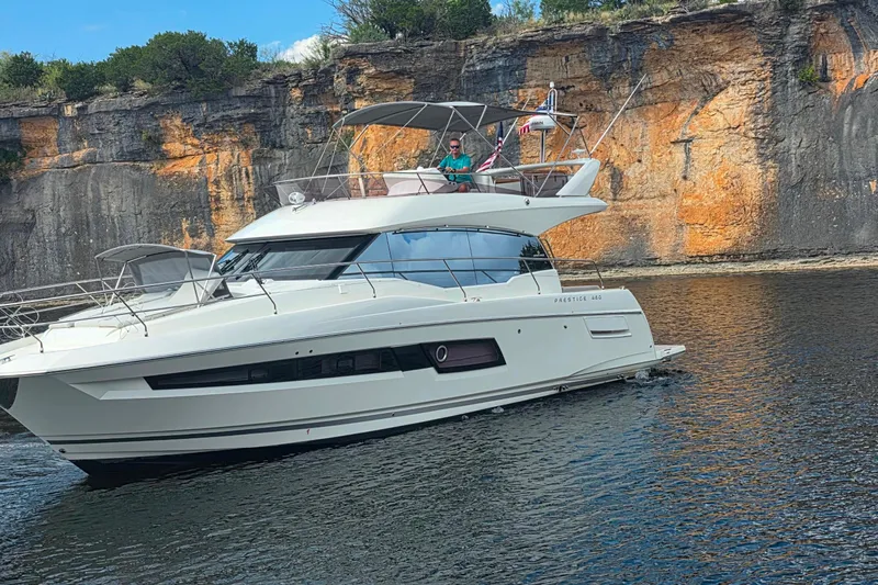 Im Your Huckelberry Yacht Photos Pics 2024 Prestige 460 yacht cruising near rocky cliffs on a sunny day.