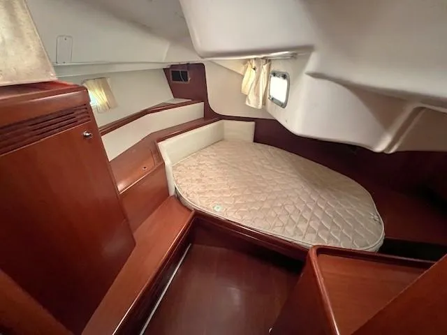 Lotus II Yacht Photos Pics 2007 Beneteau Oceanis 46 cabin with wooden interior and cozy bed.