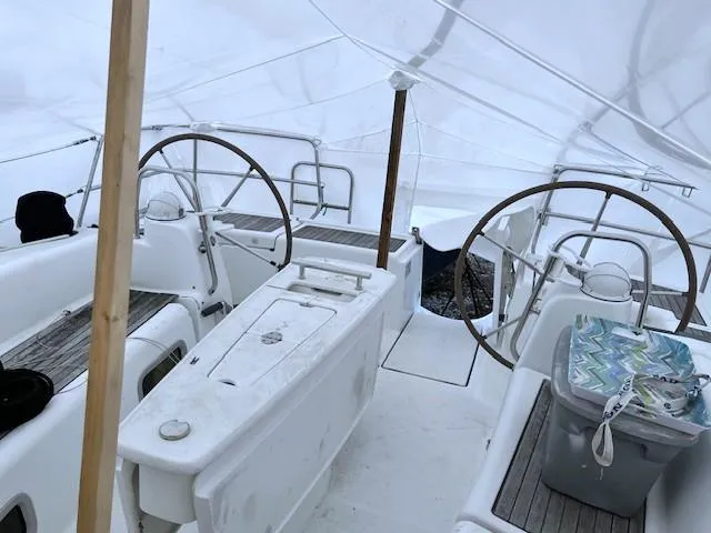 Lotus II Yacht Photos Pics 2007 Beneteau Oceanis 46 yacht cockpit under protective cover, featuring dual steering wheels.