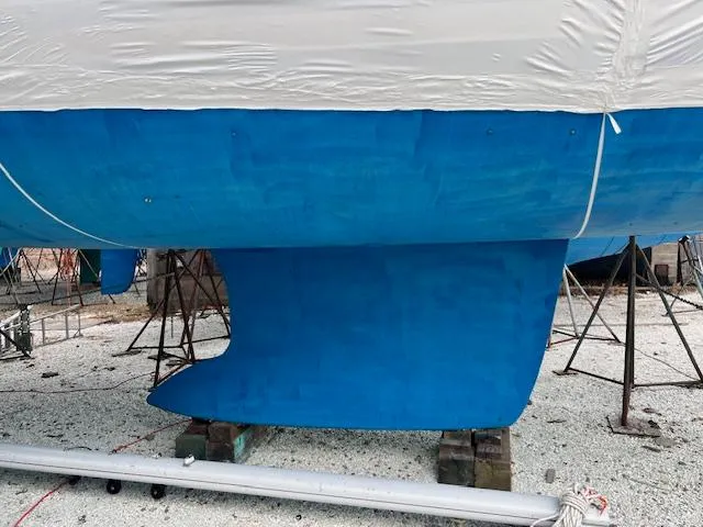 Lotus II Yacht Photos Pics Beneteau Oceanis 46 sailboat keel, 2007 model, in dry dock with blue hull.