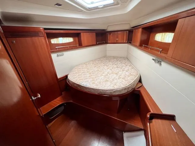 Lotus II Yacht Photos Pics 2007 Beneteau Oceanis 46 cabin with wooden interior and cozy bed.