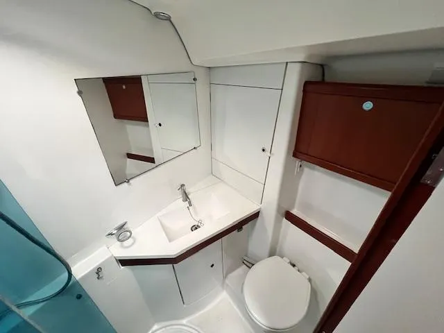 Lotus II Yacht Photos Pics Bathroom interior of 2007 Beneteau Oceanis 46 yacht, featuring sink, mirror, and storage cabinets.