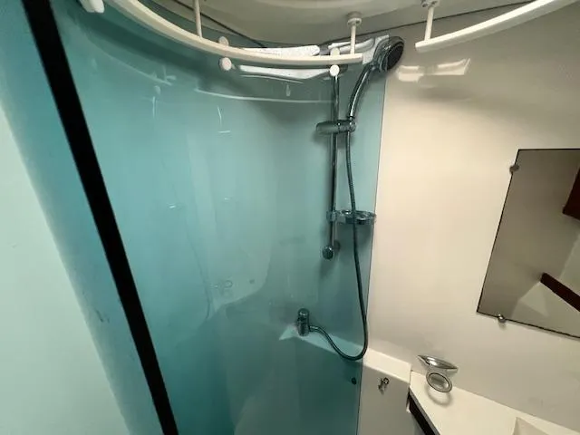 Lotus II Yacht Photos Pics Shower area in 2007 Beneteau Oceanis 46 yacht with modern fixtures and blue glass panel.
