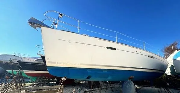 Lotus II Yacht Photos Pics 2007 Beneteau Oceanis 46 sailboat on stands, blue hull, clear sky background.