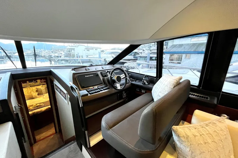  Yacht Photos Pics Interior of 2014 Prestige 500 yacht cockpit with helm, seating, and marina view.