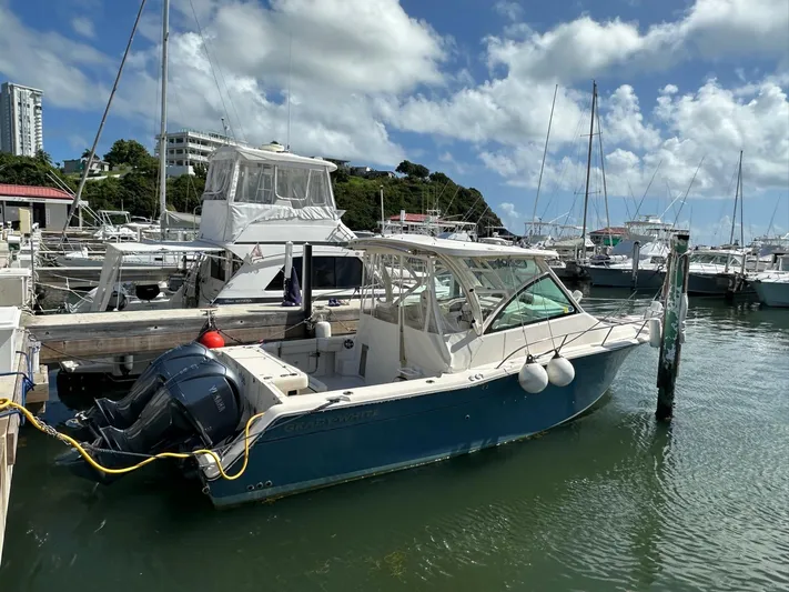  Yacht Photos Pics 2022 Grady-White Express 330 boat docked in a marina under a partly cloudy sky.
