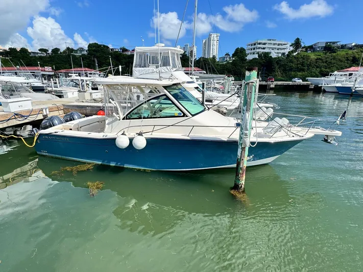  Yacht Photos Pics 2022 Grady-White Express 330 boat docked in a marina under a clear blue sky.