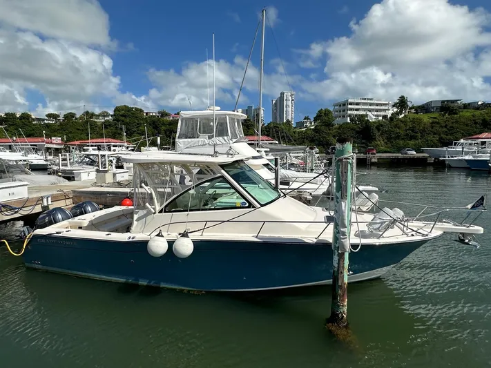  Yacht Photos Pics 2022 Grady-White Express 330 boat docked in a marina under a blue sky.