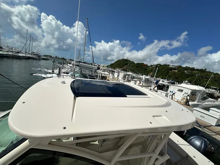  Yacht Photos Pics 2022 Grady-White Express 330 boat docked in a marina under a clear blue sky.