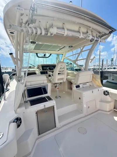  Yacht Photos Pics 2022 Grady-White Express 330 boat interior with helm and seating, under clear blue sky.