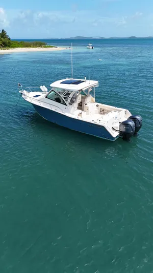  Yacht Photos Pics 2022 Grady-White Express 330 boat on clear blue water near a tropical island.