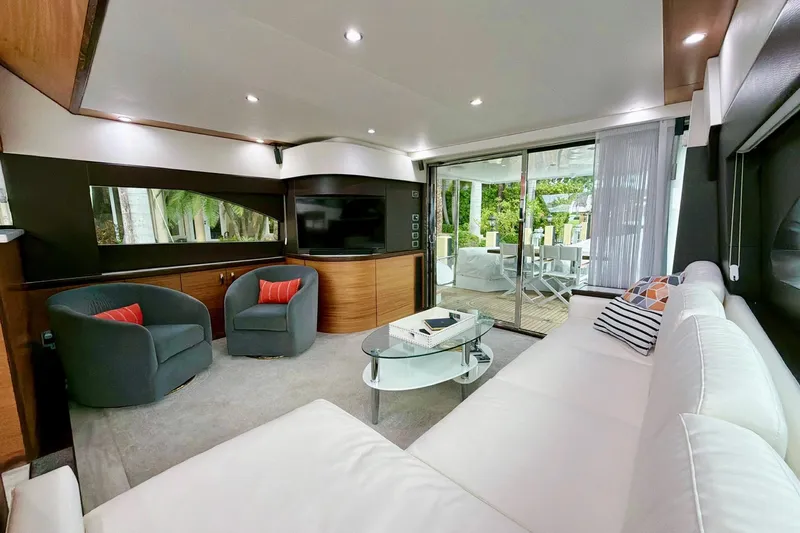 2024 Refit Yacht Photos Pics Luxurious interior of 2011 Hatteras 60 Motor Yacht with modern seating and glass doors.