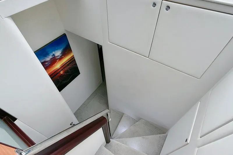 2024 Refit Yacht Photos Pics Staircase inside 2011 Hatteras 60 Motor Yacht with sunset artwork on wall.