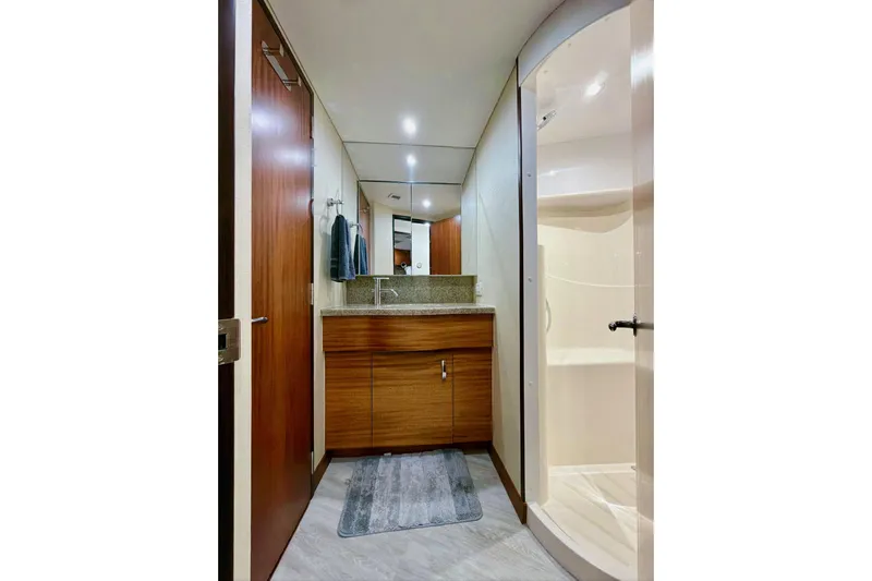 2024 Refit Yacht Photos Pics Luxurious bathroom in 2011 Hatteras 60 Motor Yacht with modern fixtures and wood cabinetry.