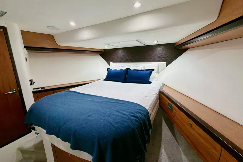 2024 Refit Yacht Photos Pics Luxurious bedroom interior of 2011 Hatteras 60 Motor Yacht with elegant wood accents.